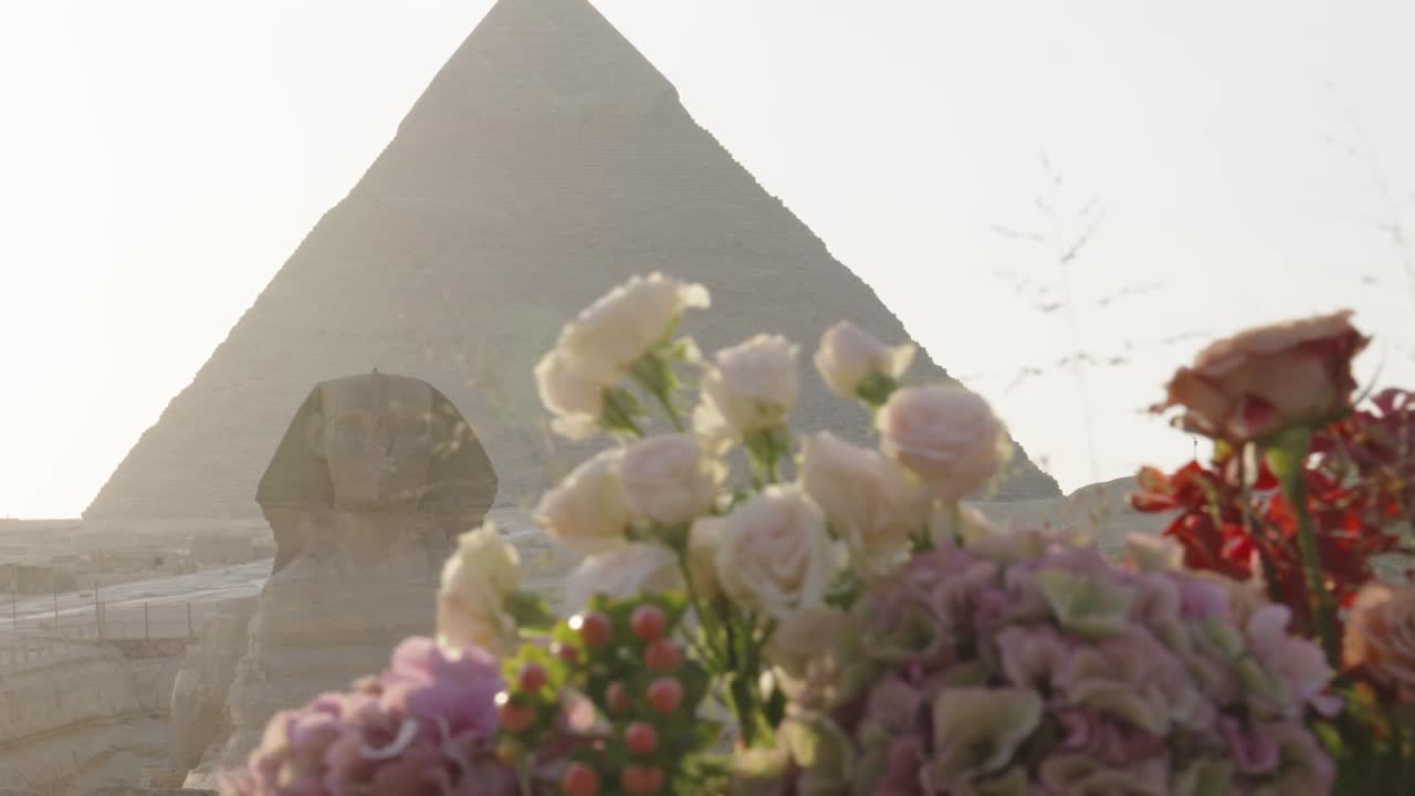 A choir performing on a terrace with the pyramids of Giza behind