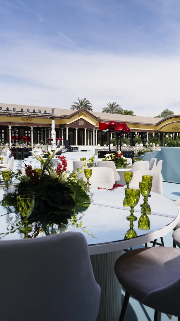 A white carpet aisle through a palace courtyard lined with columns