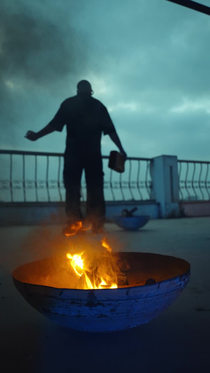 A figure on a blue-lit rooftop staircase above Cairo at night