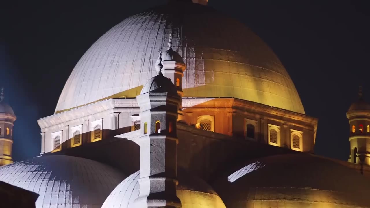 The lit dome of Mohamed Ali Mosque above a rooftop dinner