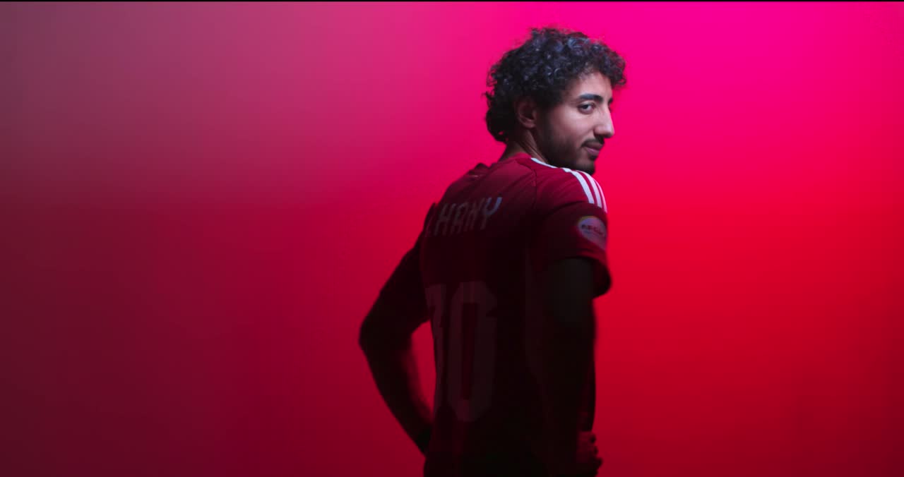 A footballer silhouetted against deep red light