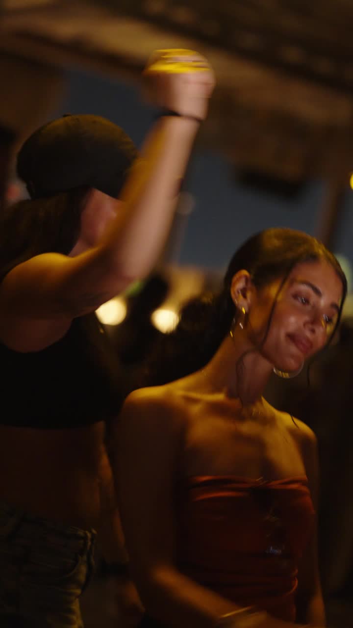 A DJ playing to a beach club crowd at dusk