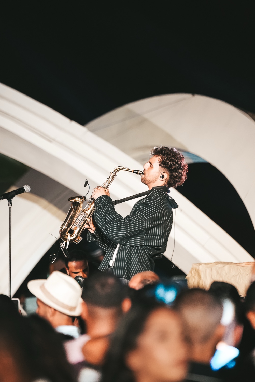A saxophonist playing from a balcony arch