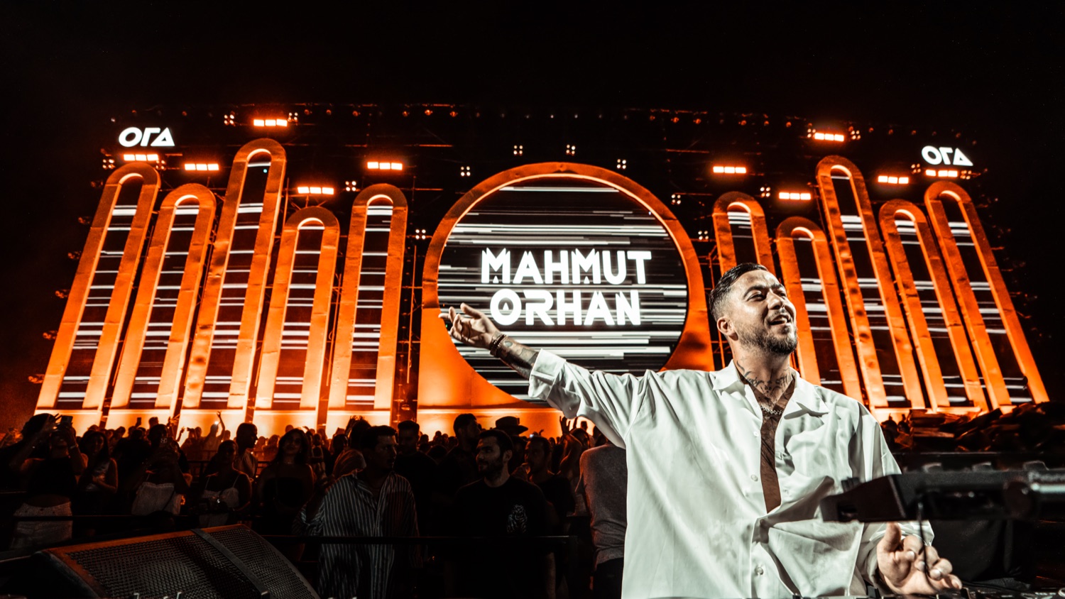 Mahmut Orhan performing on an amber-lit mainstage