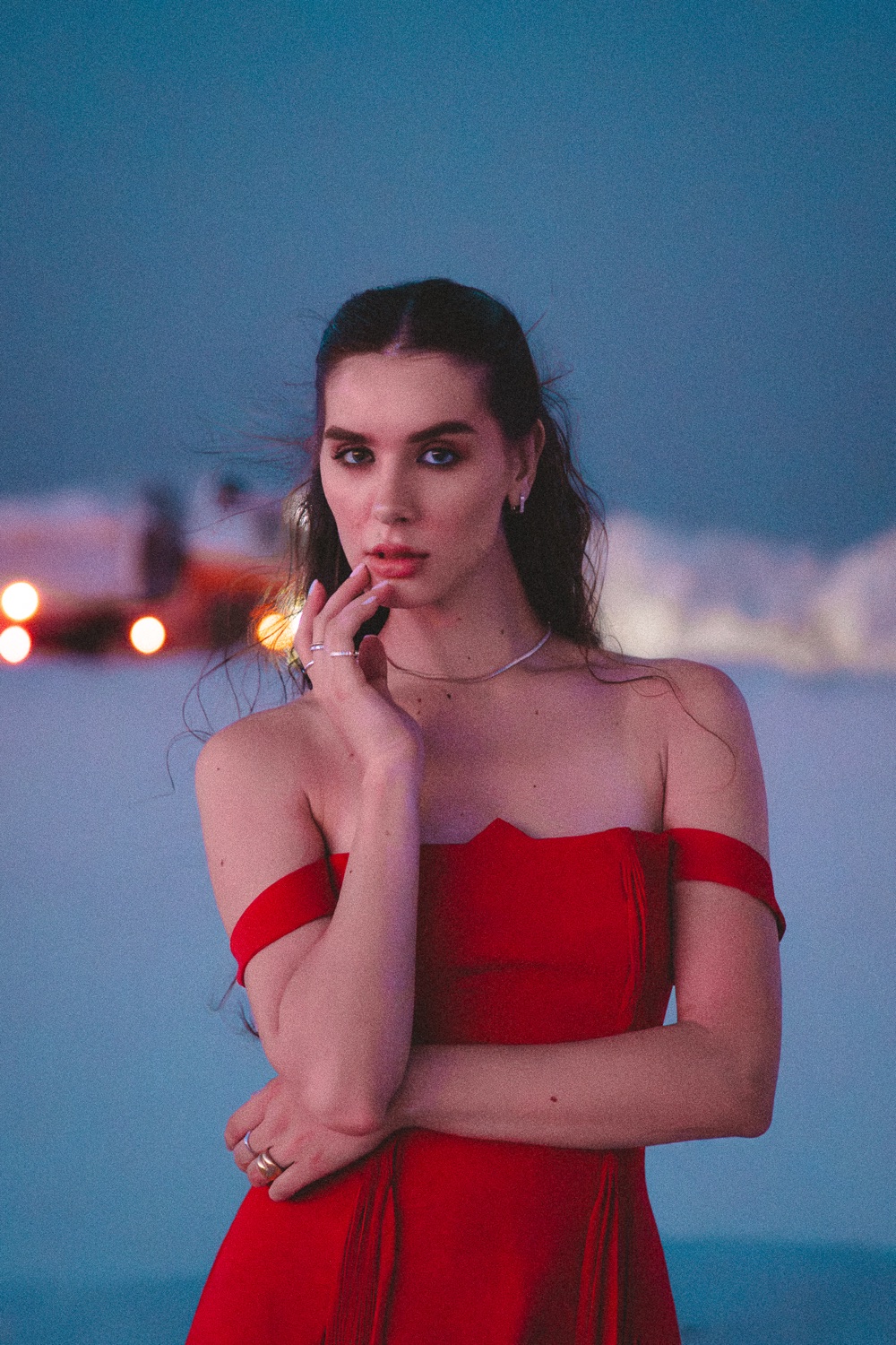 A portrait in a red dress against teal dusk