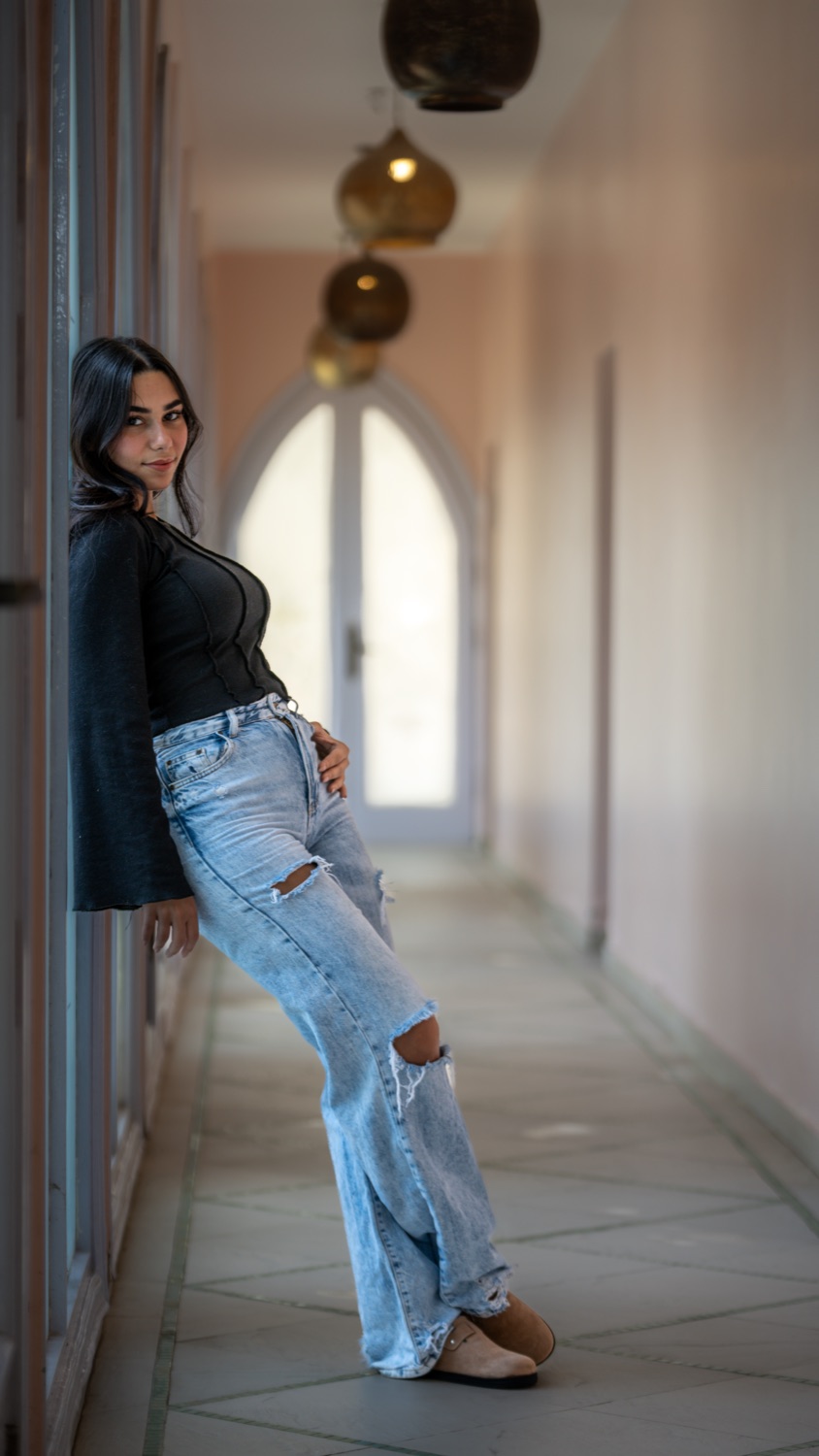 A woman leaning in a bright corridor