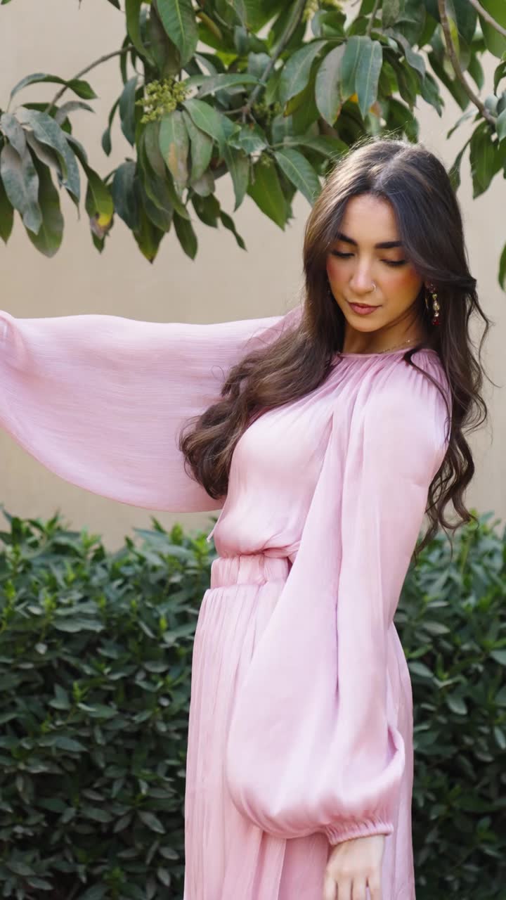 A model in a pastel dress mid-motion in a garden